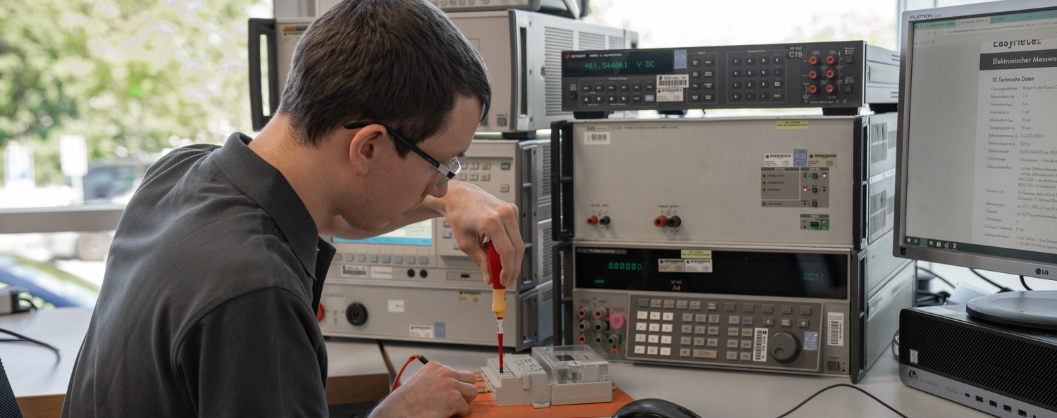 Kalibrierung von Energiezählern Ein Mann kalibriert einen Energiezähler