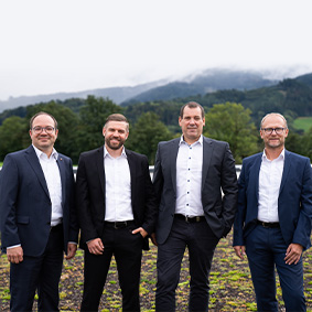 Die vier Mitglieder der Geschäftsleitung stehen vor den Bergen des Schwarzwalds.