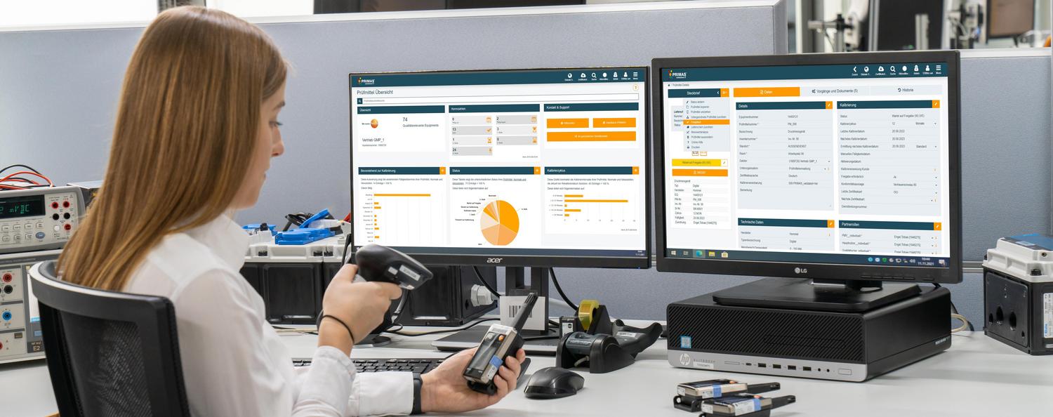 Mitarbeiterin scannt Prüfmittel und sitzt am Schreibtisch vor dem Startbildschirm von PRIMAS validated