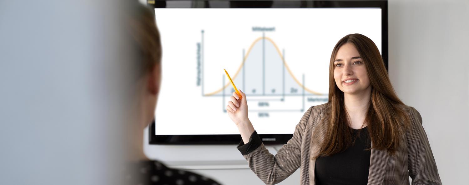 A woman presents the model of a bell curve