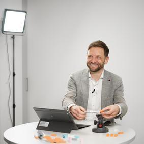 Ein Man hält ein Webinar und lächelt in die Kamera
