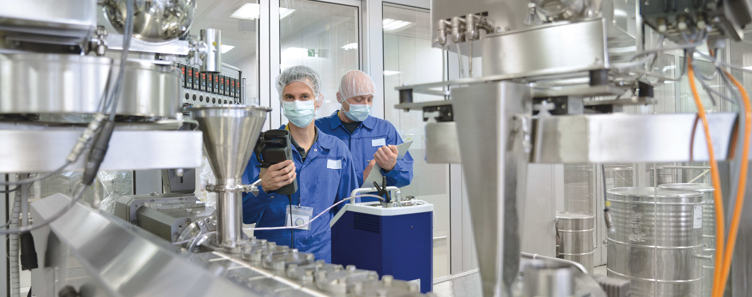 GMP-gerechte Kalibrierung Mitarbeiter kalibriert eine Messtelle an einer Produktionsanlage in einem Reinraum