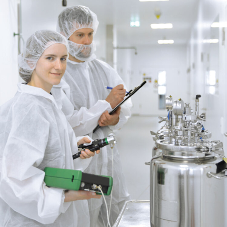 Calibration of a stationary pharmaceutical production system two persons in front of a stationary pharmaceutical production system