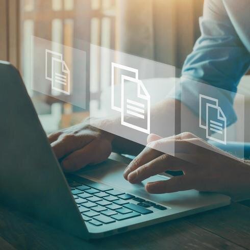 Frau an einem Notebook mit Icons für Dateien, die den Prozess der digitalen Dokumentation symbolisieren