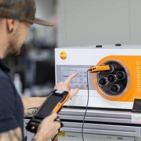 Mann in Rückansicht kalibriert einen Feuchtesensor in einem Huminator