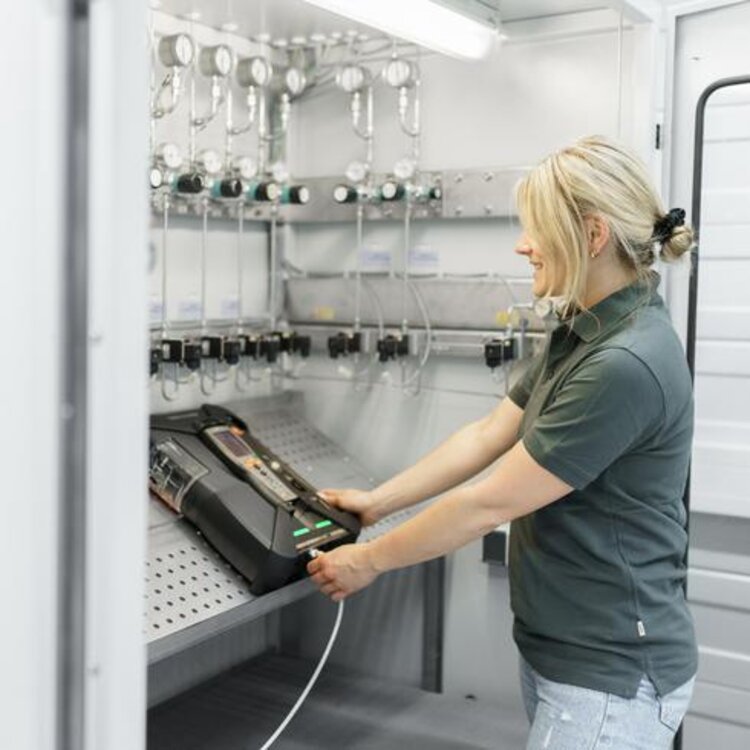 Kalibrierung eines Testo-Rauchgasmessgeräts durch eine Mitarbeiterin
