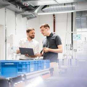 Zwei Männer in einem Labor sehen auf einen Laptop
