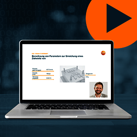 Screenshot des Webinars mit Foto des Referenten auf dem Bildschirm eines Laptops vor blauem Hintergrund