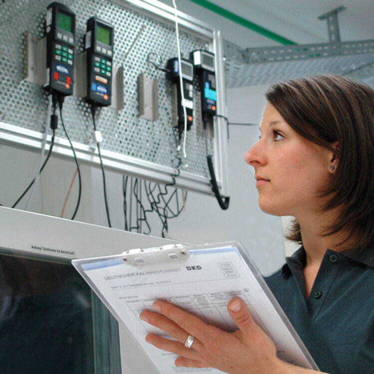 Calibration of your humidity measuring instruments Woman with clipboard at a humidity calibration test bench